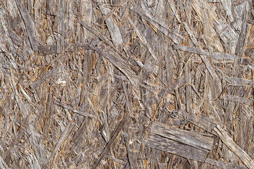 Close-up of chipboard weathered by wind, rain and sun. Particle board backgrounds