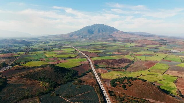Highway crosses agave fields and borders Sanganguey volcano in Tepic, Mexico. Aerial View