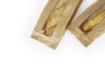 Two freshly baked baguettes, wrapped in brown paper bag, Artisan French baguettes with crispy crusts in paper packaging. Isolated on a white background. Closeup. Copy space