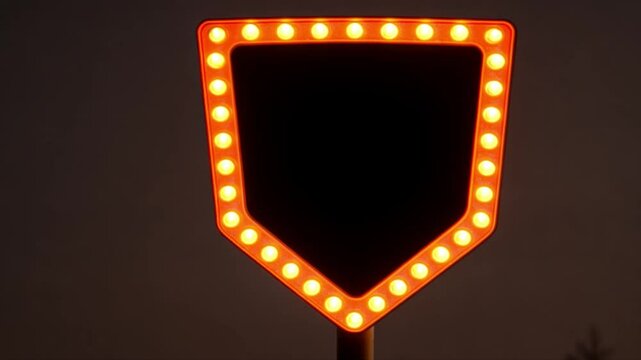 Illuminated Home Plate Sign at Night