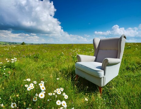 Un fauteuil gris pos&eacute; dans une prairie d'herbe verte luxuriante, sous un ciel bleu avec des nuages ​​blancs moelleux en arri&egrave;re-plan en ia
