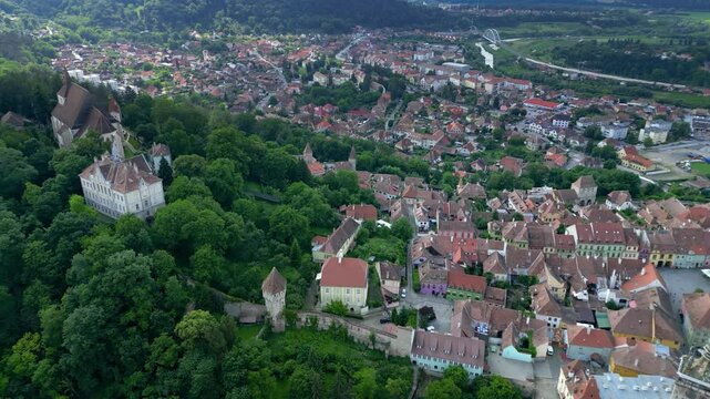 Historic centre of Sighisoara, Romania, aerial view. It is a popular tourist destination for its well-preserved old town, which is listed by UNESCO, World Heritage Site. Drone backwards ascending.