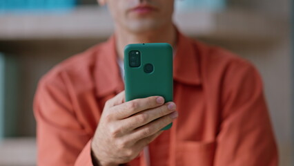 Businessman hand holding mobile phone at company workplace closeup crop view. 
