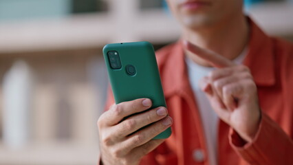 Blogger hand touching smartphone posting in social media in apartment closeup. 