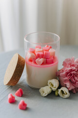 Tender white candle with small pink hearts.