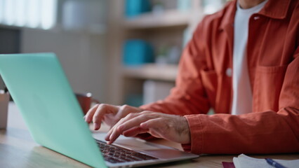 Employee hands inputting data in laptop sitting modern company workplace closeup