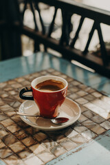 Cup of black coffee on a table in a street cafe.