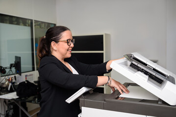 Teacher preparing documents using photocopier in language academy