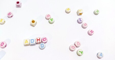 ADHD in alphabet beads on white background.