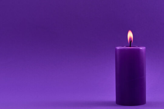 Purple Candle. A single purple candle burning with a soft flame - Powered by Adobe