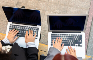 Businesswomen, partners working on laptops in the park