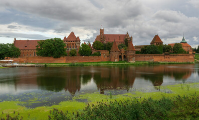 Obraz premium Panorama of the castle Teutonic Castle Malbork in the light of the setting sun.