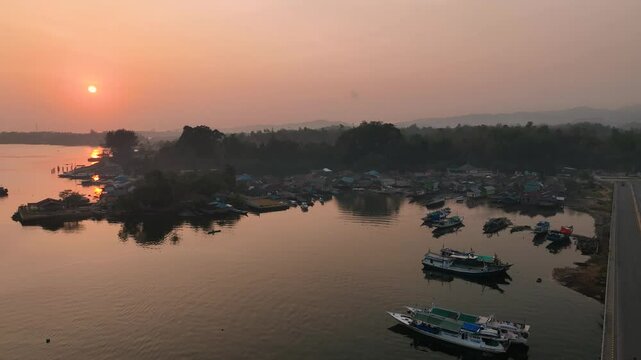 4k aerial footage of the sunset on the Kendari Bay Bridge which has become a tourist icon in Southeast Sulawesi, Indonesia. Golden yellow twilight aerial panorama of the iconic suspension bridge