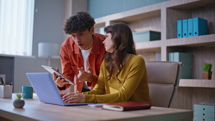 Colleagues brainstorming solutions together in collaborative office environment.