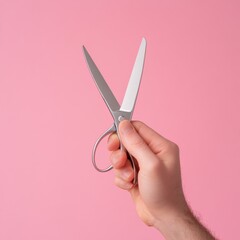 hand holding a pair of scissors against a pink background