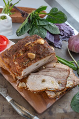Baked piece of pork - ham. Delicious spicy meat. Spicy meat baked with garlic and chili peppers. A piece of baked meat with spices and vegetables on the table