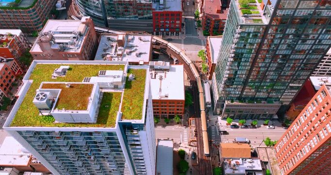 Train on elevated tracks within buildings at the Loop, Glass and steel bridge between buildings in Chicago City center. Aerial view.