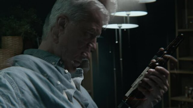 Drunk lowkey vision of mature Caucasian man drinking beer spending evening at home alone and feeling dizzy of excessive amount of alcohol