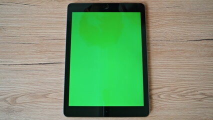 Hands surfing online chroma key tablet on wooden desk closeup. Unknown man