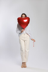 Happy Valentine's Day. Beautiful woman with heart shaped balloon on white background