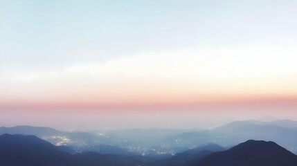 Fototapeta premium Serene sunset over misty mountain range with city lights.