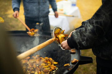 Busy street food fair scene with potato cooking