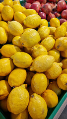 Sale of lemons in a supermarket. Citrus fruits in plastic boxes, close-up. Lemons in a store. Ripe, juicy, bright yellow lemons. A pile of lemons for sale at the market