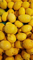 Sale of lemons in a supermarket. Citrus fruits in plastic boxes, close-up. Lemons in a store. Ripe, juicy, bright yellow lemons. A pile of lemons for sale at the market