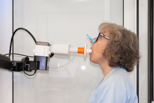 Woman with nose clip undergoing spirometry test in pneumology department