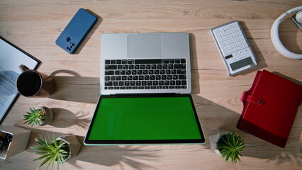 Modern workplace green screen laptop top view closeup. Empty office workspace 