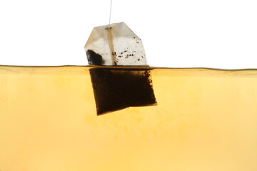 Putting tea bag into glass cup on white background, closeup