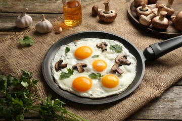 Tasty fried eggs with mushrooms and parsley served on wooden table