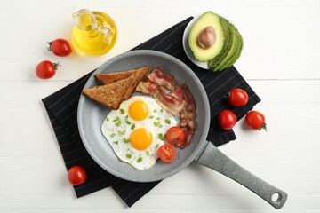 Tasty fried eggs with bacon and toasts served on white wooden table, flat lay