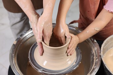 Hobby and craft. Mother with her daughter making pottery indoors, closeup