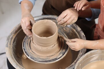 Hobby and craft. Mother with her daughter making pottery indoors, closeup