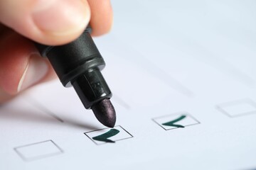Woman checking box of paper form, closeup