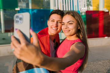 Lesbian Couple Taking a Selfie with Pride and Transgender Flags
