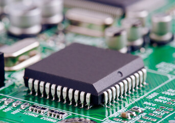 Close-up view of a microchip on a green circuit board