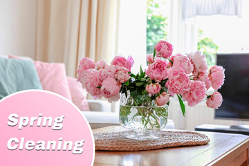 Spring cleaning. Beautiful pink peonies in glass vase on table