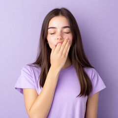 Fototapeta premium young woman yawning and covering her mouth with her hand
