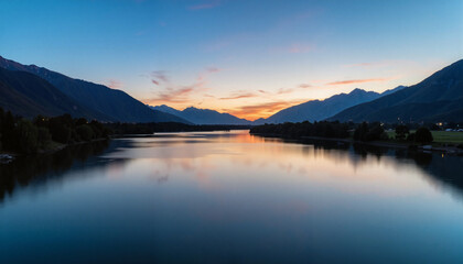 Evening reflection on calm river with mountain silhouettes, tranquility