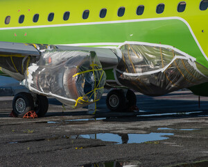 An airplane turbine undergoing repairs is wrapped in film. 