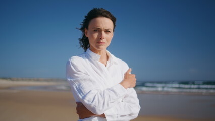 Pensive lady walking sea coast spending weekend on gold sandy beach closeup.