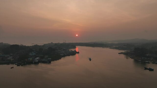 4k aerial footage of the sunset on the Kendari Bay Bridge which has become a tourist icon in Southeast Sulawesi, Indonesia. Golden yellow twilight aerial panorama of the iconic suspension bridge