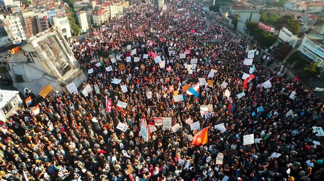 Crowds of people gathering in an urban location, expressing their views through banners and chants during a significant public demonstration