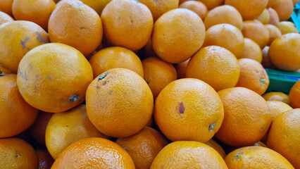 Oranges for sale in a supermarket. Citrus fruits in plastic boxes, close-up with selective focus. Oranges in a store. Ripe, juicy, bright orange fruits. Fruits enriched with vitamin C