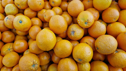Oranges for sale in a supermarket. Citrus fruits, close-up with selective focus. Oranges in a store. Ripe, juicy, bright orange fruits. Fruits enriched with vitamin C