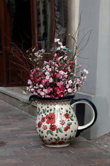 big ceramic mug and posy of colorful plastic flowers as decoration about shop