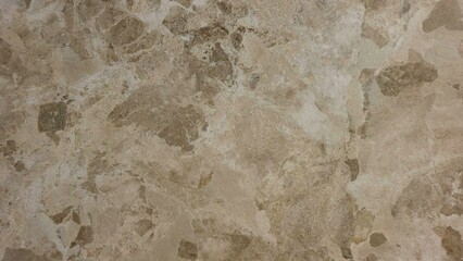 A tan and brown tile floor with a few spots of dirt