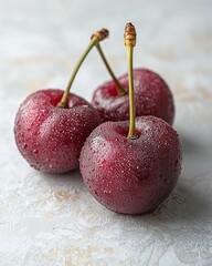 Three dewy cherries on light marble for food or drink visuals